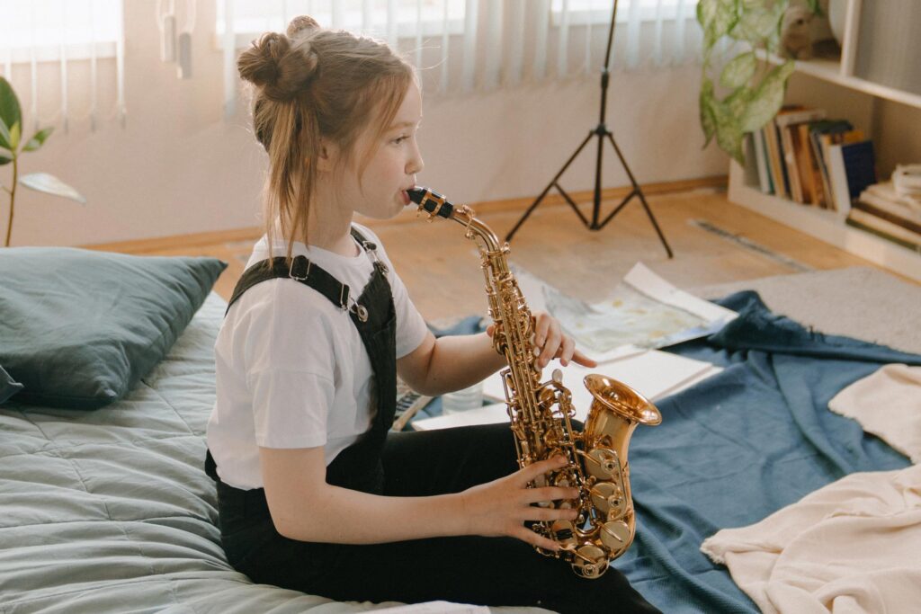 Niña ensayando con un saxofón